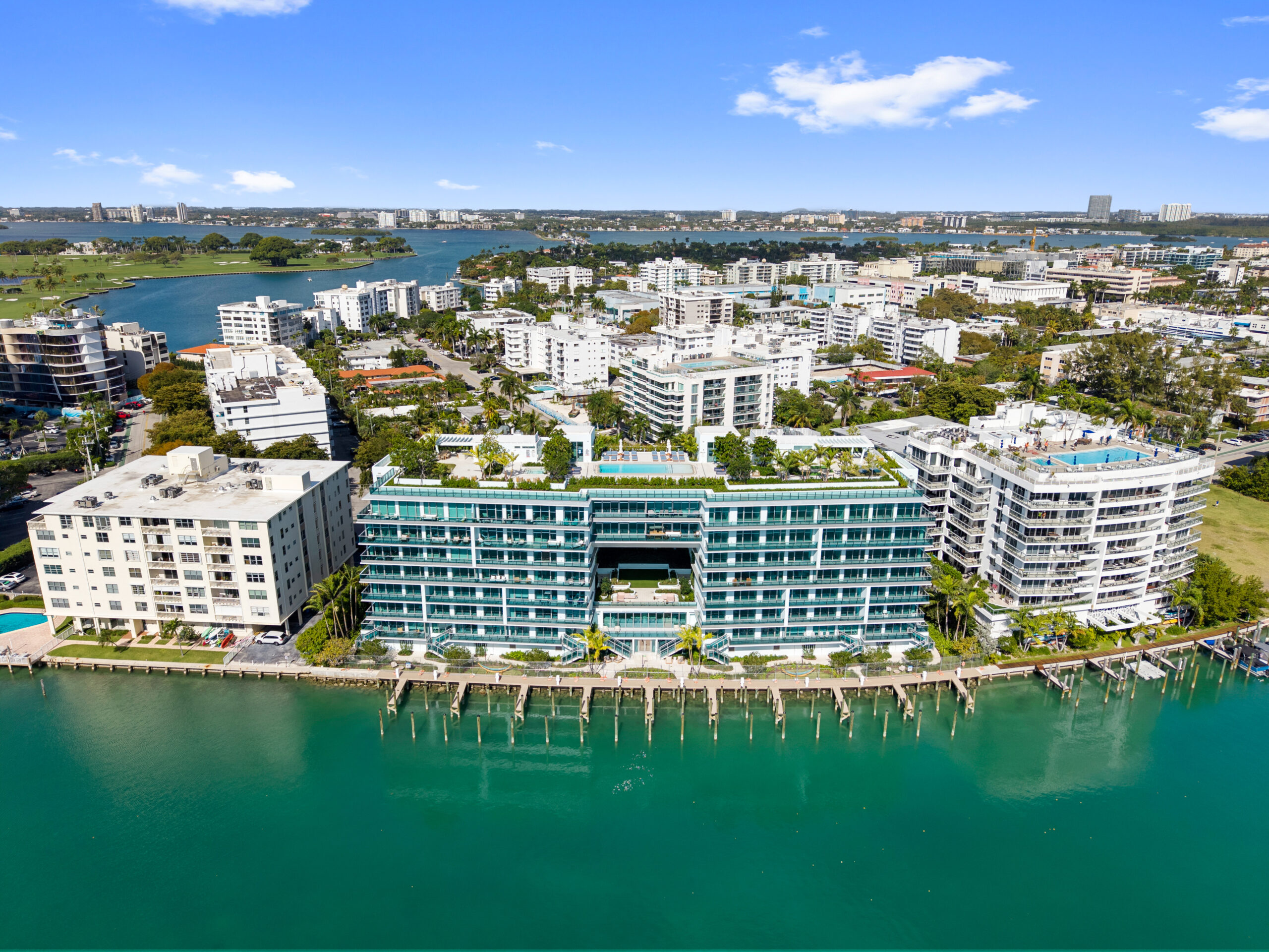 Modern luxury waterfront condo tower in Bay Harbor Islands with glass façade and rooftop pool