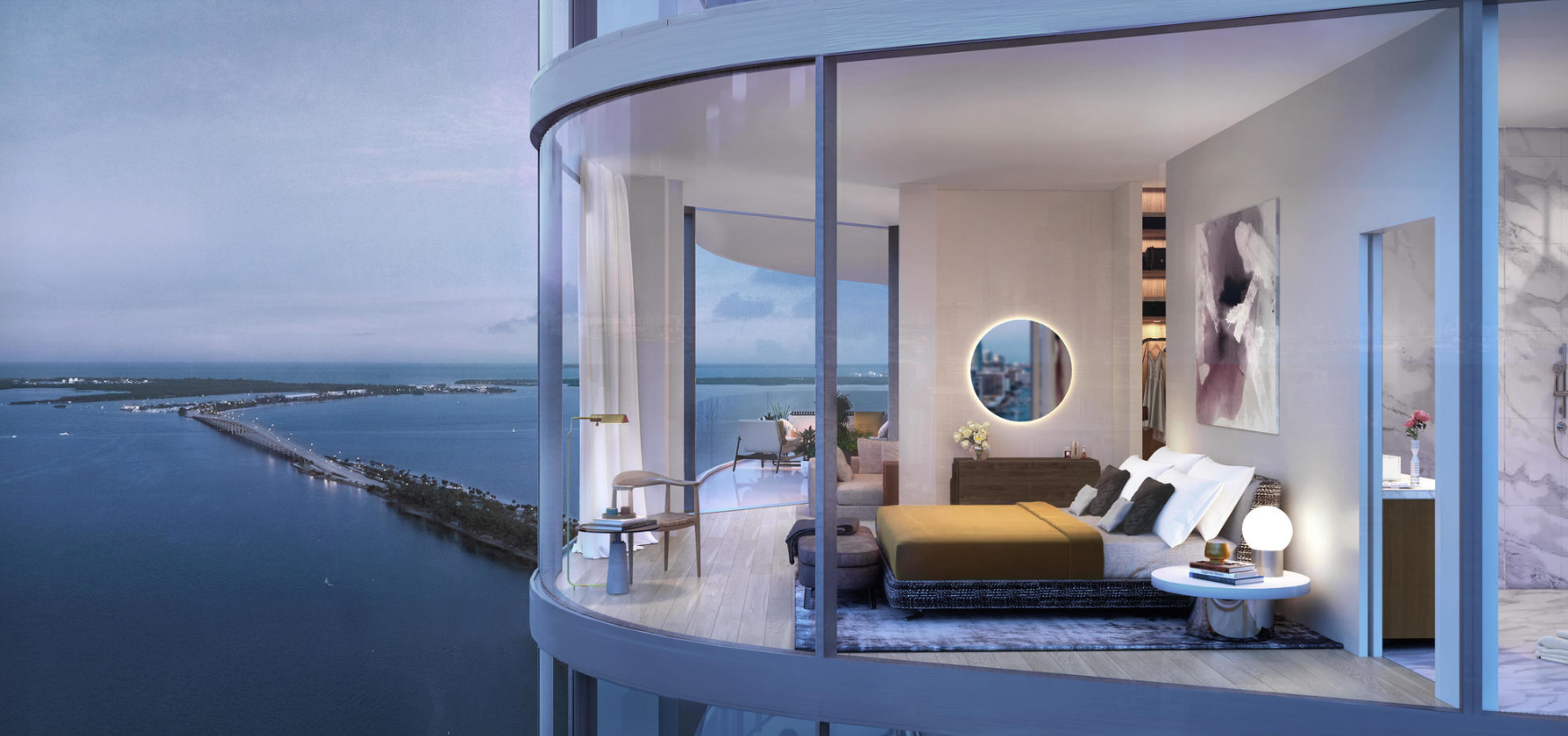 Waterfront corner residence at UNA Residences Miami with curved glass balcony, open living area and unobstructed Biscayne Bay views