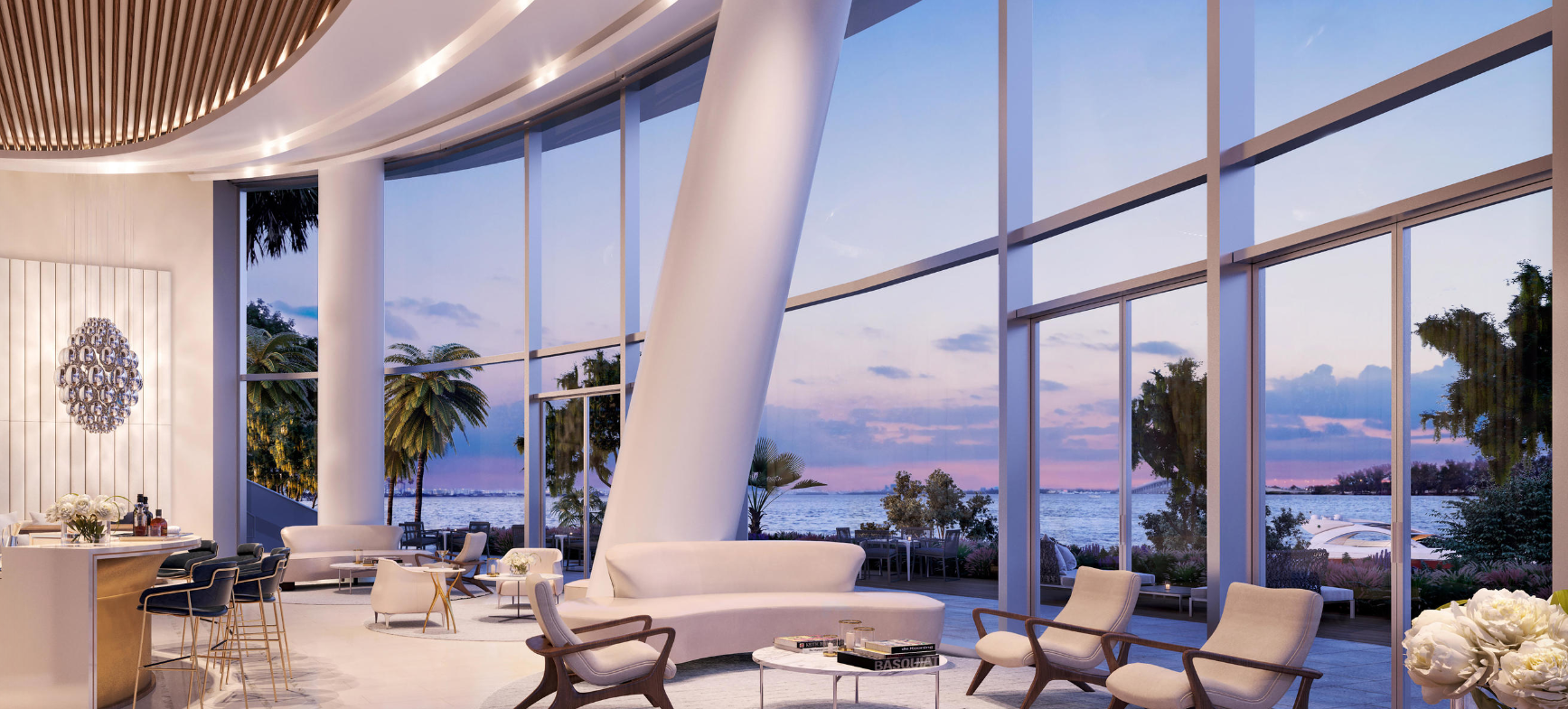 Bayfront lounge at UNA Residences Miami with floor‑to‑ceiling glass, modern seating and sunset views over Biscayne Bay